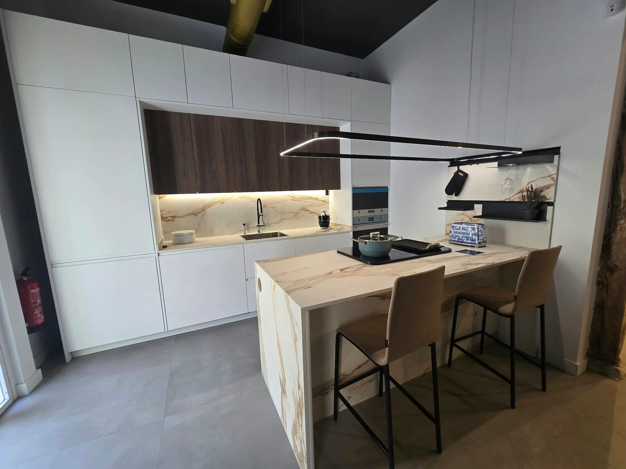 Exposición de la tienda: cocina blanca con nogal e isla